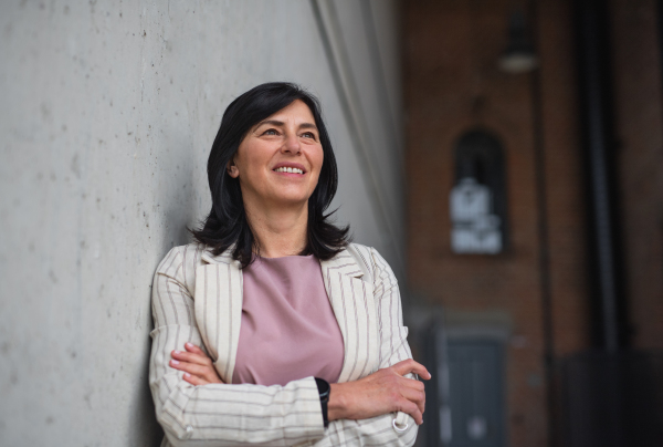 Front view of portrait of senior businesswoman standing indoors in office.