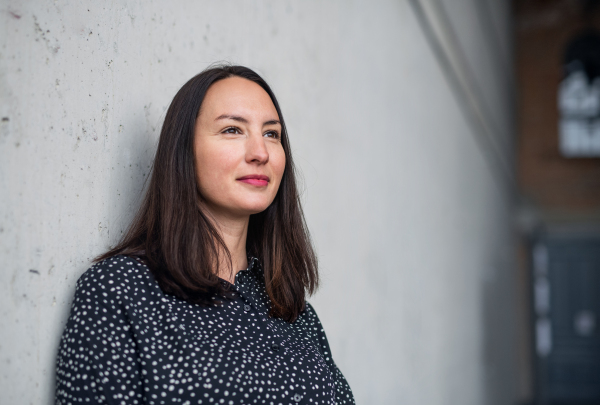 A portrait of mid adult businesswoman standing indoors. Copy space.