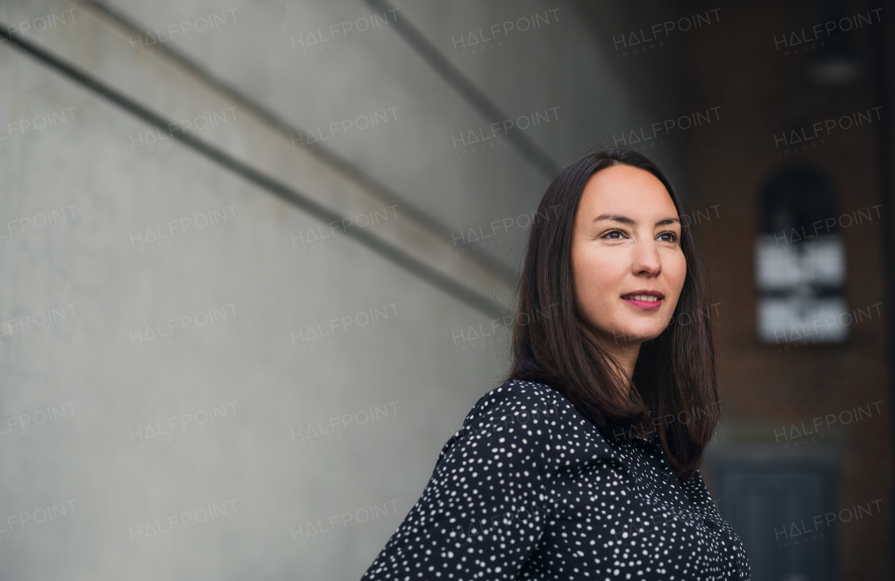 A portrait of mid adult businesswoman standing indoors. Copy space.