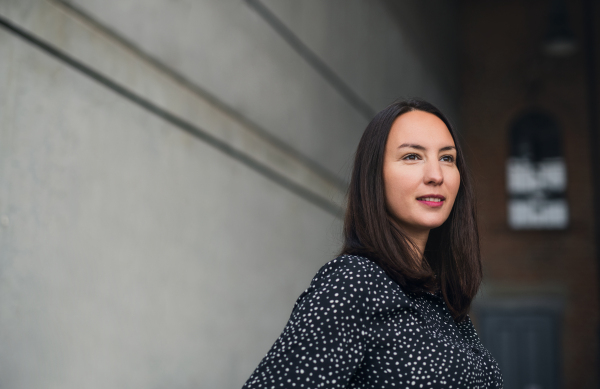 A portrait of mid adult businesswoman standing indoors. Copy space.