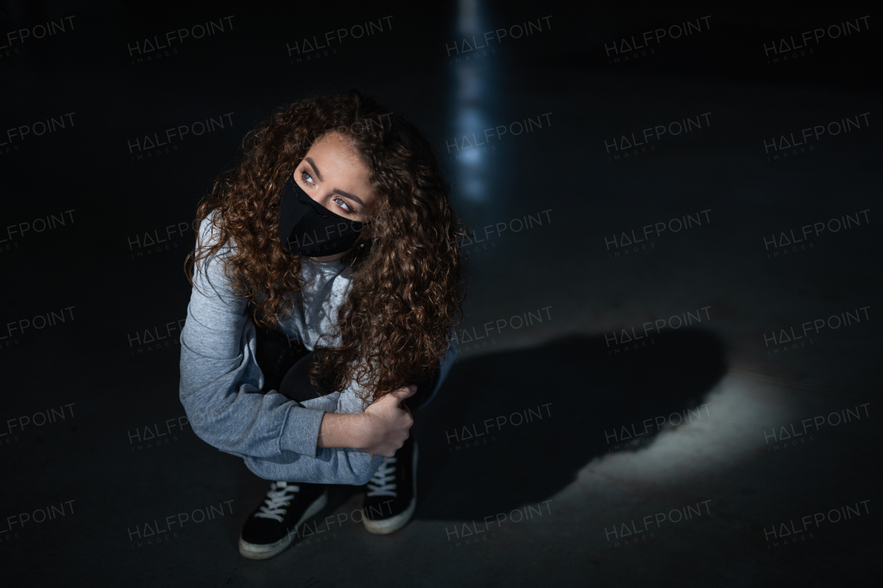 A top view portrait of depressed young woman indoors, covid-19 and mental health concept.