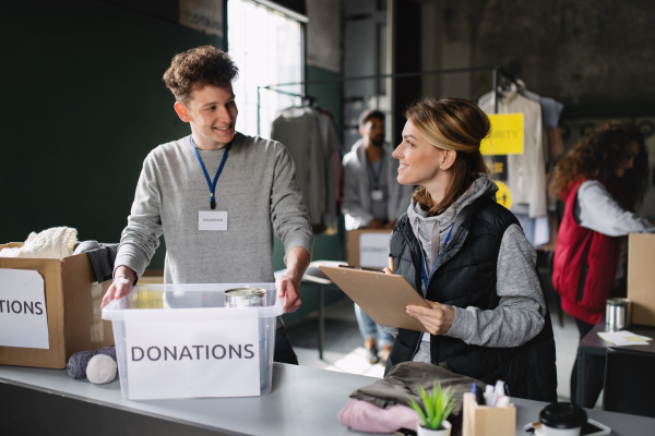 A group of volunteers working in community charity donation center, talking.