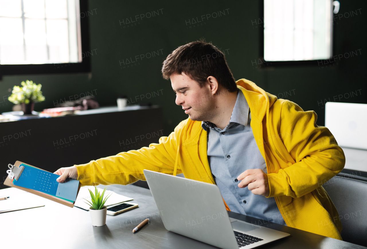 A down-syndrome man attending education class in community center, inclusivity of disabled person.