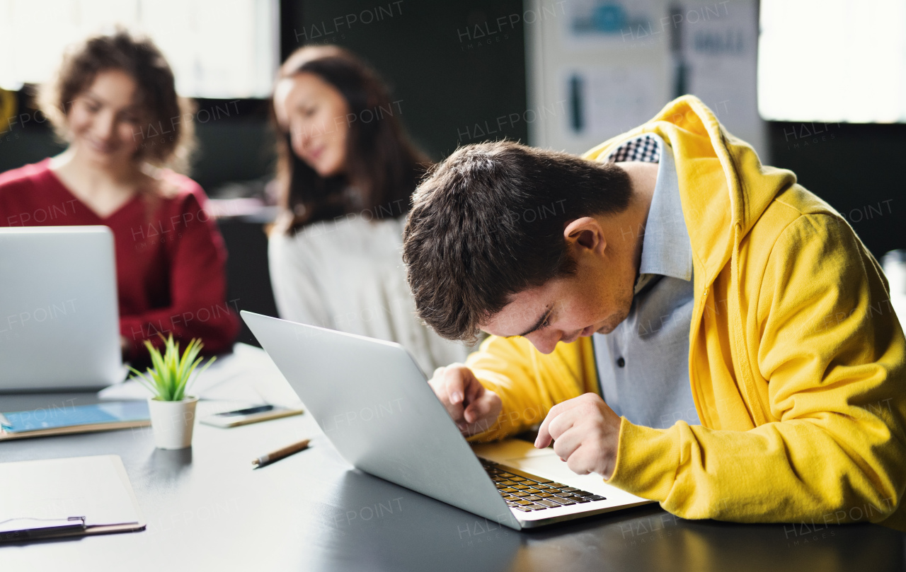 A down-syndrome man with laptop attending education class in community center, inclusivity of disabled person.