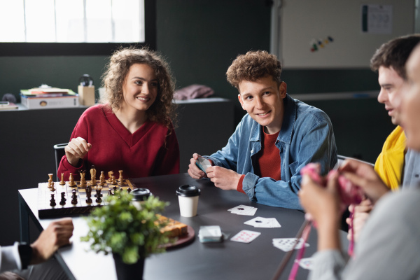 Group of happy people playing cards and board games in community center, inclusivity of disabled person.