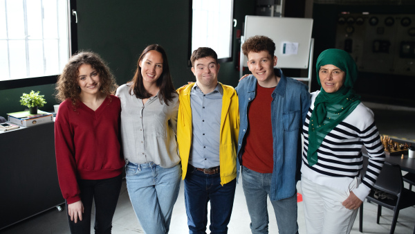 Down syndrome man with friends looking at camera in community center, inclusivity and unity concept.