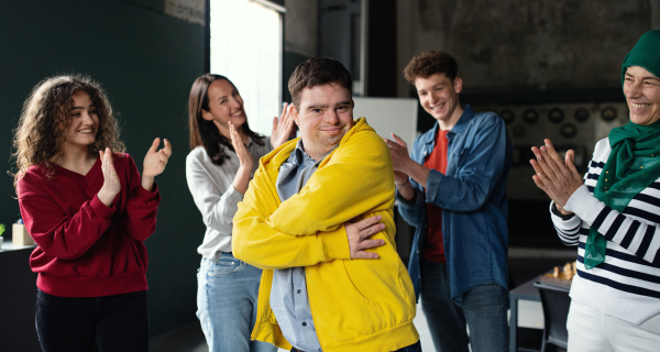 Down syndrome man with friends looking at camera in community center, inclusivity and unity concept.