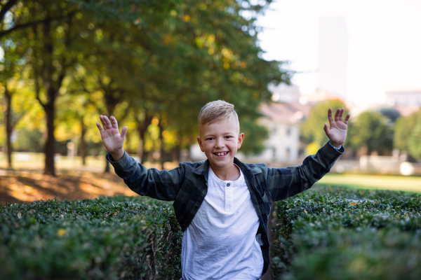 A happy little boy running and looking at camera outoodrs in park