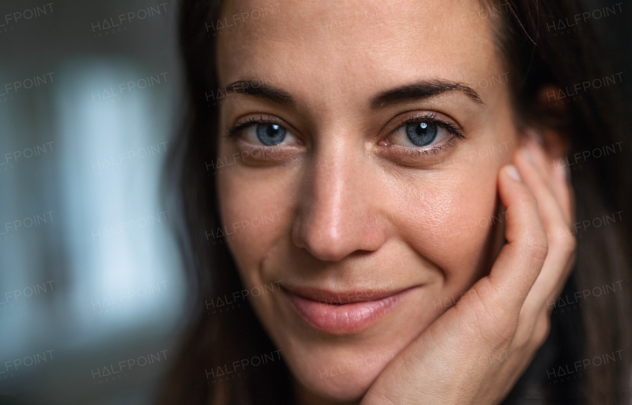 Close-up of atractive businesswoman standing indoors in office, looking at camera.