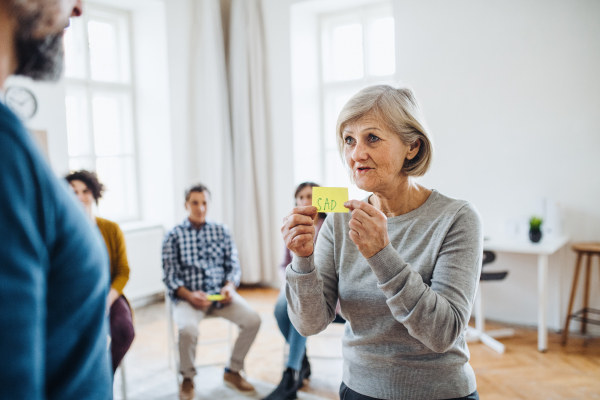 Group of men and women during group therapy, expressing negative emotions.