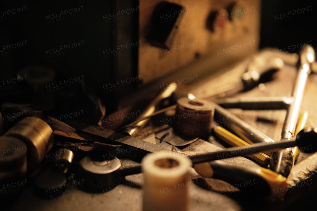 A close up of industrial tools indoors in metal workshop at night.