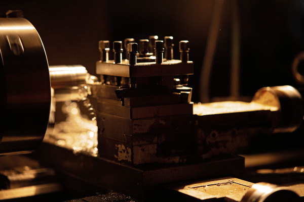 A close up of industrial machines indoors in metal workshop at night.