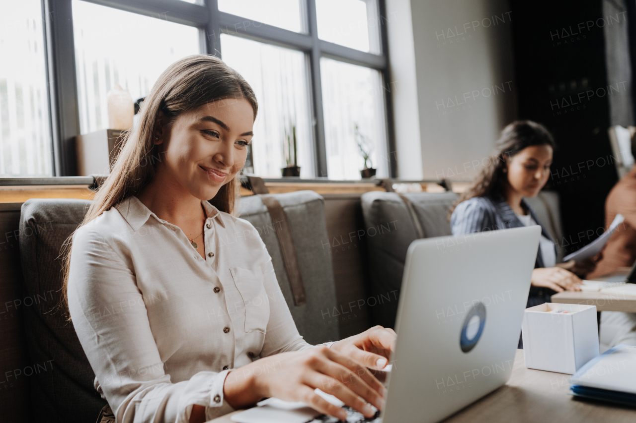 Group of freelancers and remote businesspeople working in shared work area. Concept of coworking, common workspaces for business, startups. Working remotely from coffee shop.