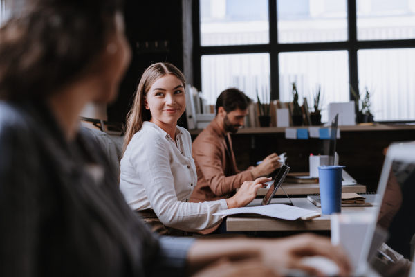 Group of freelancers and remote businesspeople working in shared work area. Concept of coworking, common workspaces for business, startups. Working remotely from coffee shop.