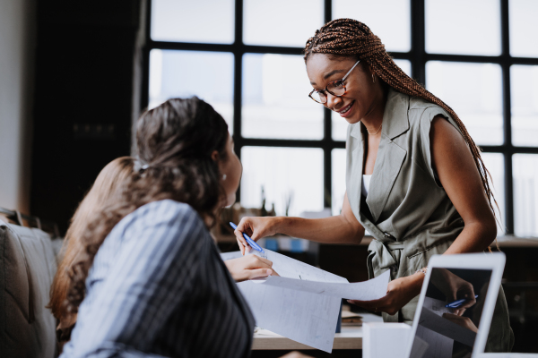 People in coworking space sharing ideas, collaboring, talking about project. Group of freelancers and remote businesspeople working in shared work area. Concept of coworking as modern working arragement. Working remotely from coffee shop.