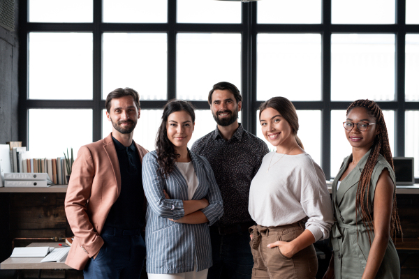 Group of colleagues standing in modern office, looking at camera. Concept of teamwork, diverse team for business, startups. Team portrait.