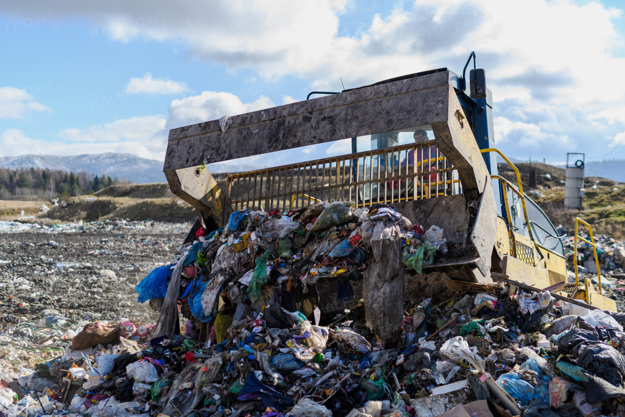 Garbage truck unloading waste on landfill, environmental concept. Copy space.