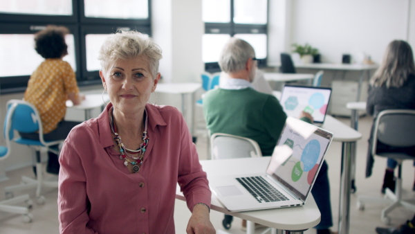 A senior woman attending computer and technology education class.