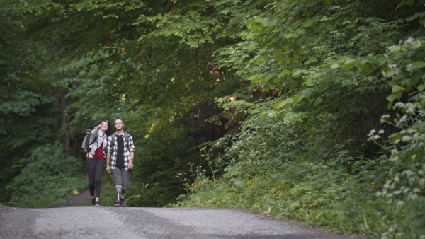 Disabled young man wearing leg prosthetis enjoying a walk outdoors with his assitant friend.