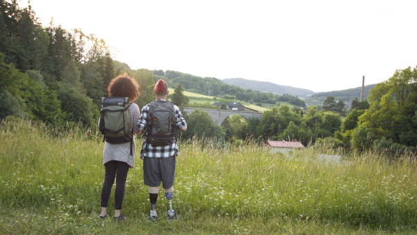 Disabled young man with friend on nature walk enjoying the wonderful view outdoors.