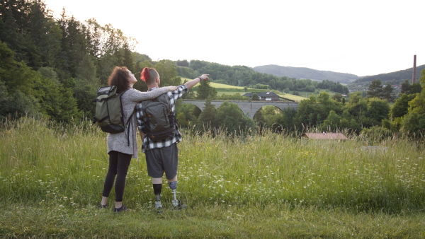 Disabled young man with friend on nature walk enjoying the wonderful view outdoors.