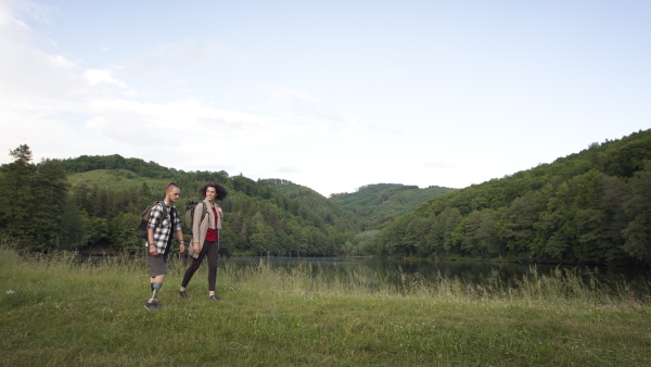 Disabled young man wearing prosthetis enjoying a walk outdoors with his assitant friend.