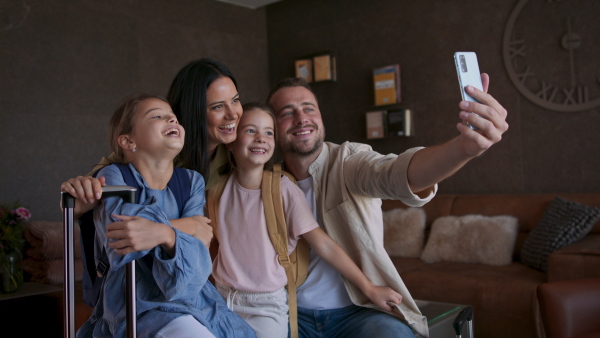 A happy young family with two children taking selfie at luxury hotel, summer holiday.