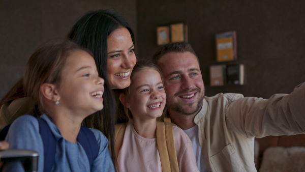 A happy young family with two children taking selfie at luxury hotel, summer holiday.