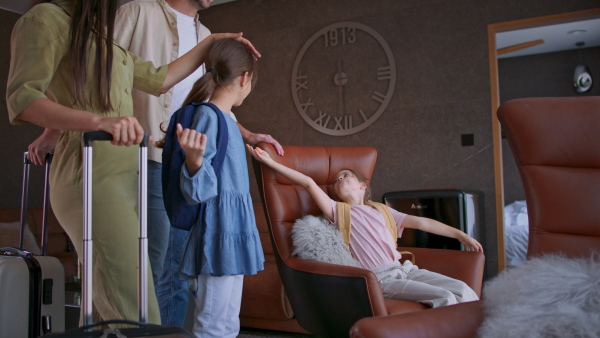 A happy young family with two children enetring room at luxury hotel, summer holiday.