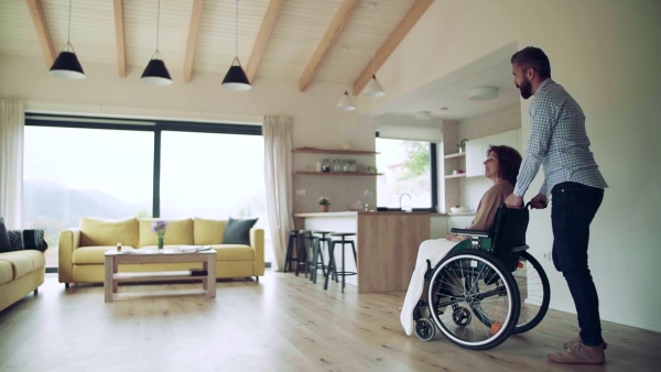 Health visitor and a disabled senior woman in wheelchair during home visit. Slow motion.