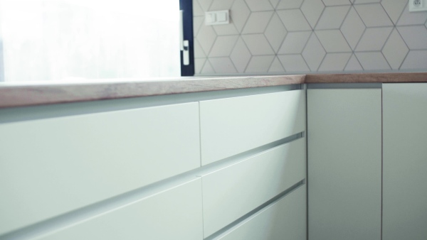 A close-up view of modern kitchen cupboards in house or flat in new home. A moving in new home concept.