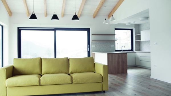 A yellow sofa in modern interior of a house or flat in new home. A moving in new home concept.