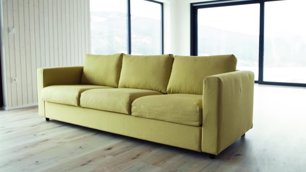 A yellow sofa in modern interior of a house or flat in new home. A moving in new home concept.