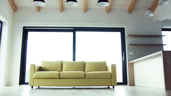 A yellow sofa in modern interior of a house or flat in new home. A moving in new home concept.