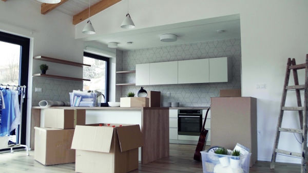 Moving boxes, ladder and clothes rack on the floor in new home. A moving in new home concept.