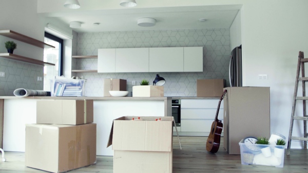 Moving boxes, ladder and clothes rack on the floor in new home. A moving in new home concept.