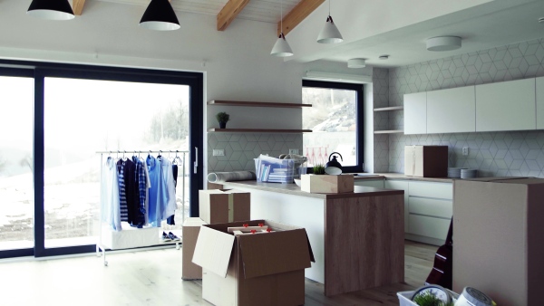 Moving boxes and clothes rack on the floor in new home. A moving in new home concept.