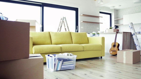 Moving boxes, ladder and clothes rack on the floor in new home. A moving in new home concept.