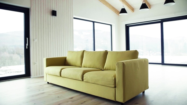 A yellow sofa in modern interior of a house or flat in new home. A moving in new home concept. Slow motion.