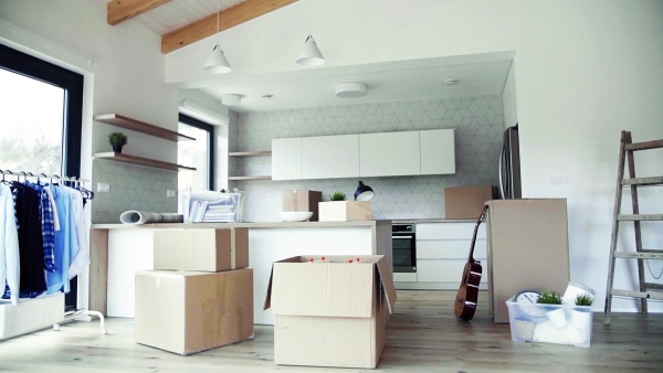 Moving boxes, ladder and clothes rack on the floor in new home. A moving in new home concept. Slow motion.