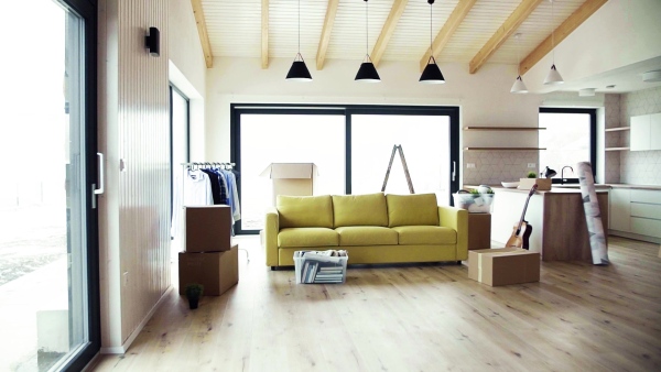 Moving boxes, sofa and clothes rack on the floor in new home. A moving in new home concept. Slow motion.