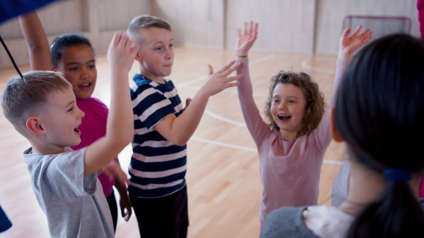 School sports teammates rising up hands after winning the sports indoor competition