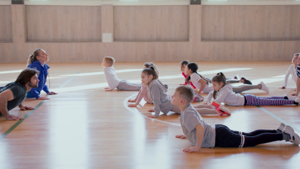 A group of elementary students exercising during class at school gym.