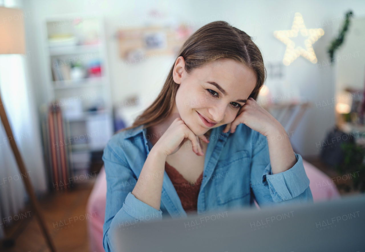 Beautiful happy young girl with laptop sitting and smiling, online dating and chatting concept.