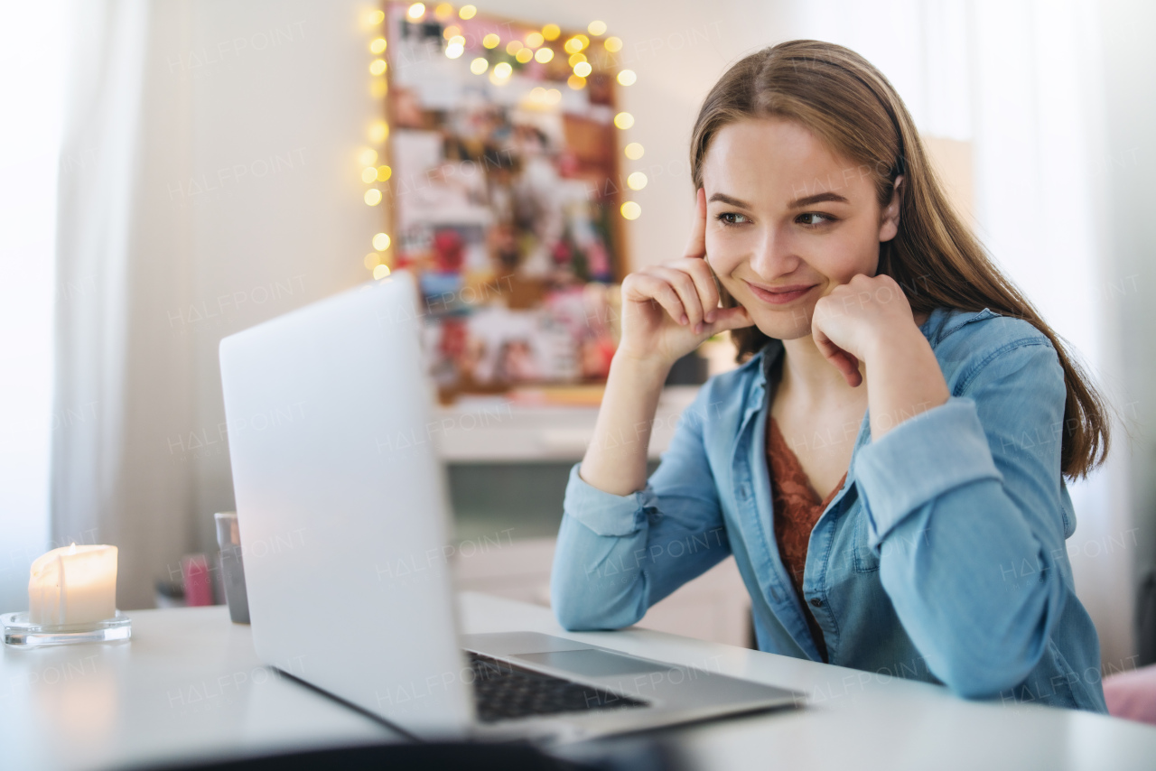 Beautiful happy young girl with laptop sitting and smiling, online dating and chatting concept.