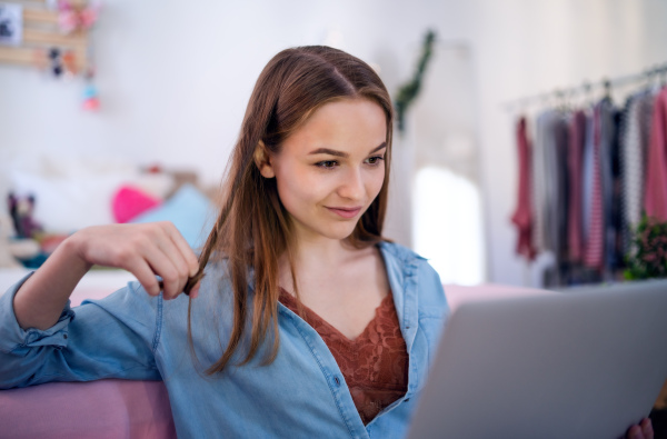 Beautiful happy young girl with laptop sitting and smiling, online dating and chatting concept.