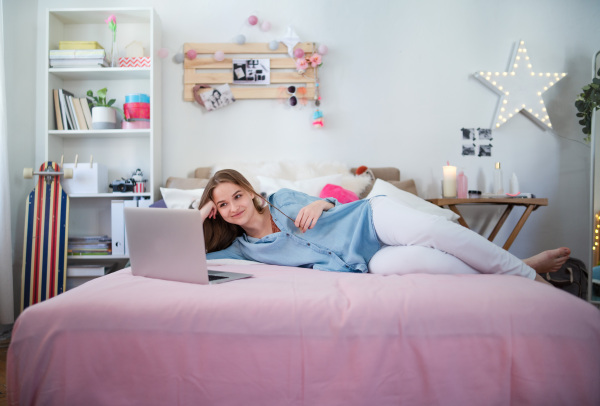 Beautiful happy young girl with laptop sitting and smiling, online dating and chatting concept.