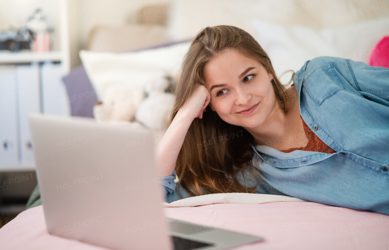 Beautiful happy young girl with laptop sitting and smiling, online dating and chatting concept.