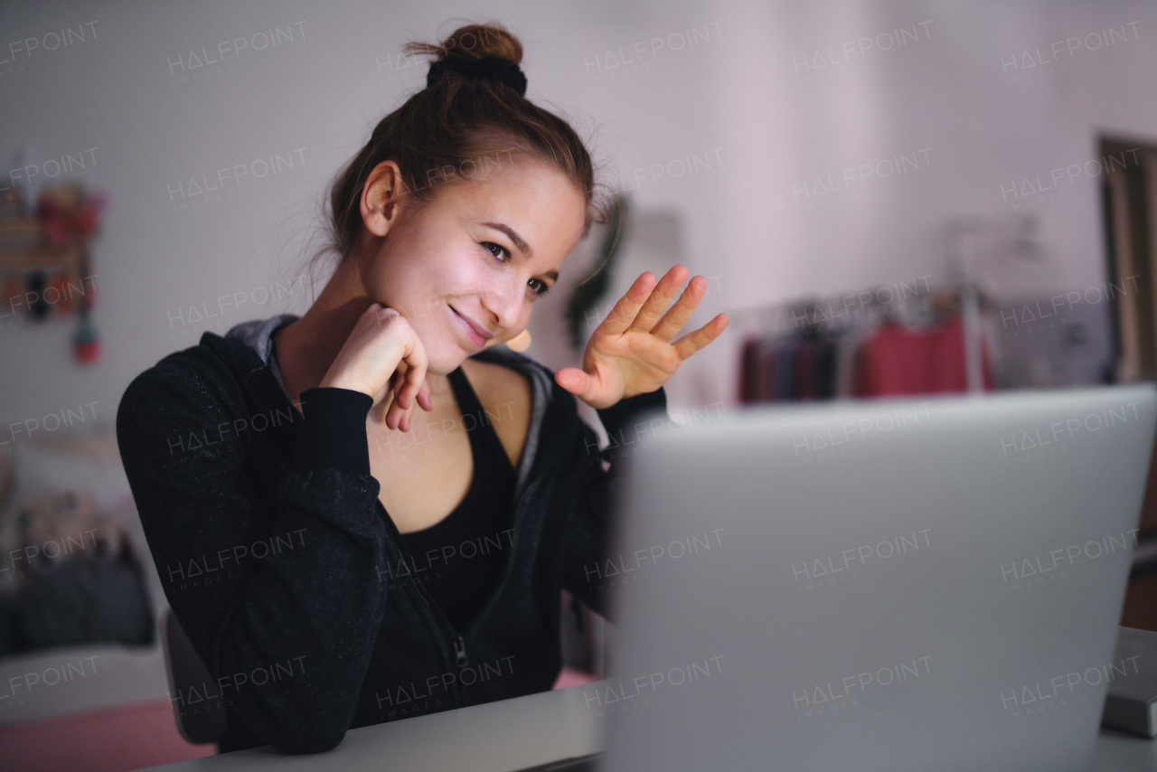 Beautiful happy young girl with laptop sitting and smiling, online dating and chatting concept.