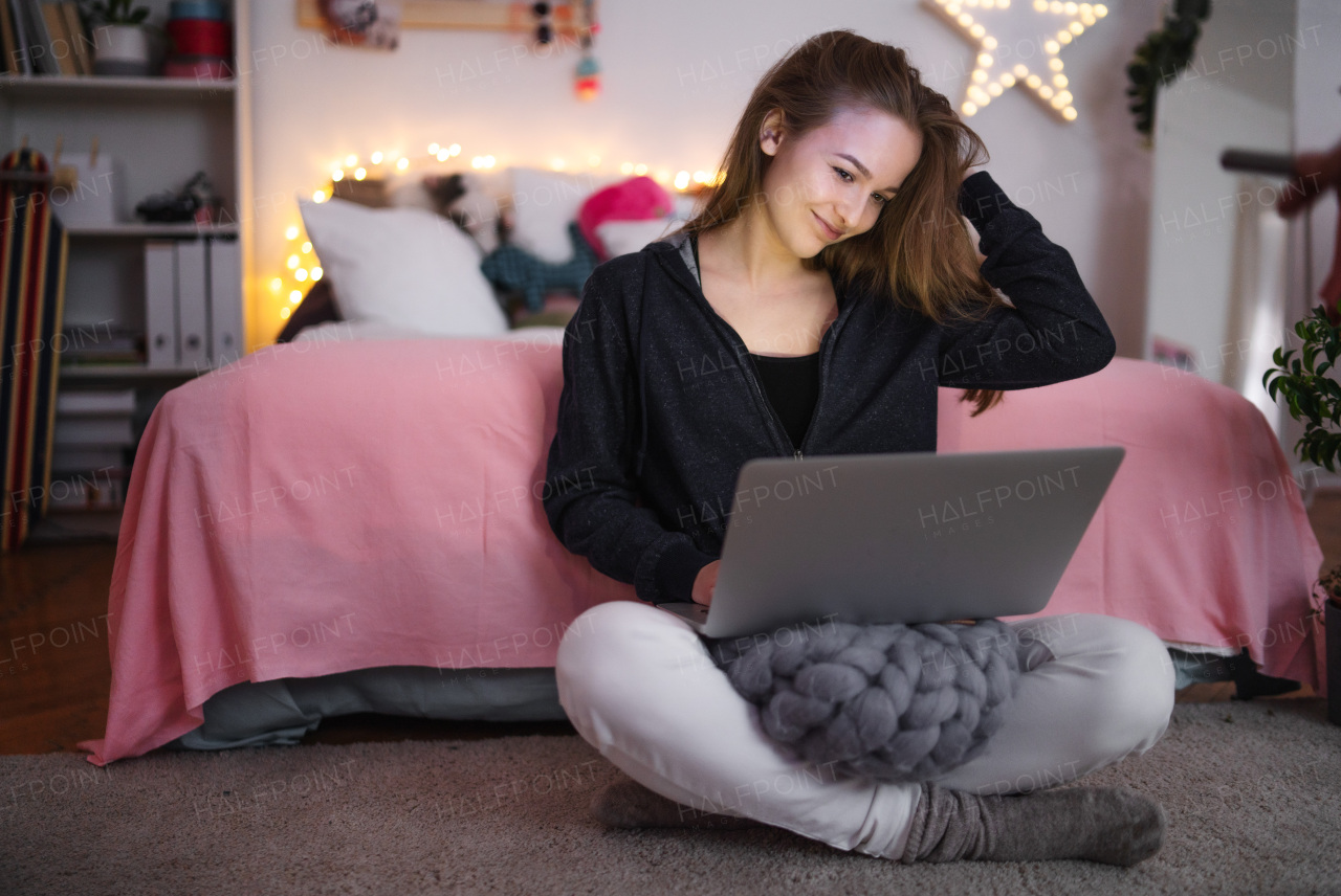 Beautiful happy young girl with laptop sitting and smiling, online dating and chatting concept.